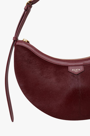 Alaïa Demi Lune Hair Calf Bag in Garnet Red